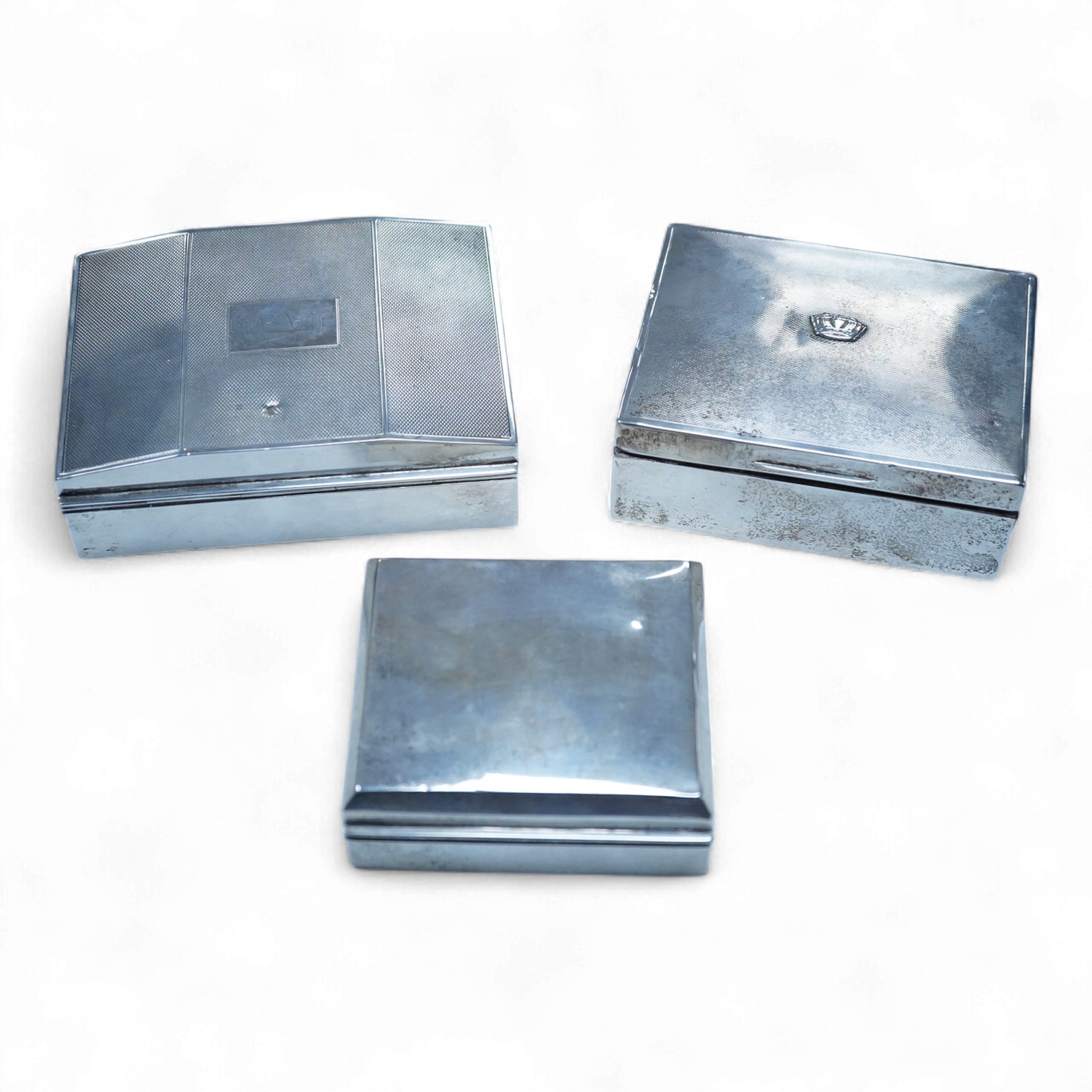 Three assorted George V/George VI silver mounted cigarette boxes, including two with engine tuned covers, the largest by Joseph Gloster Ltd, Birmingham, 1946, 12.8cm.